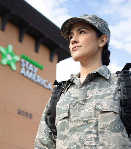 woman in military fatigues outside extended stay hotel